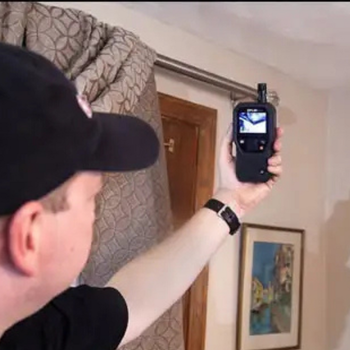Teledyne Flir Mr176 Kit5 man using device near curtain inspection.