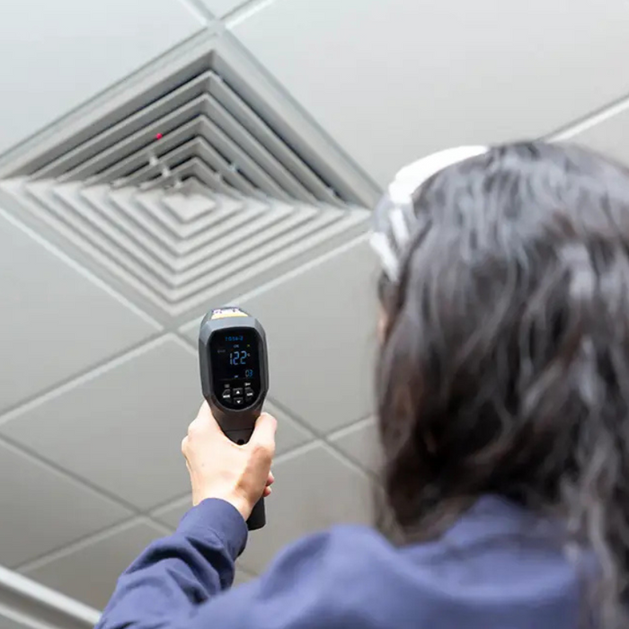 Teledyne Flir Sv89 Remote Vibration Temperature Sensor worker aiming sensor at ceiling vent gray ceiling.