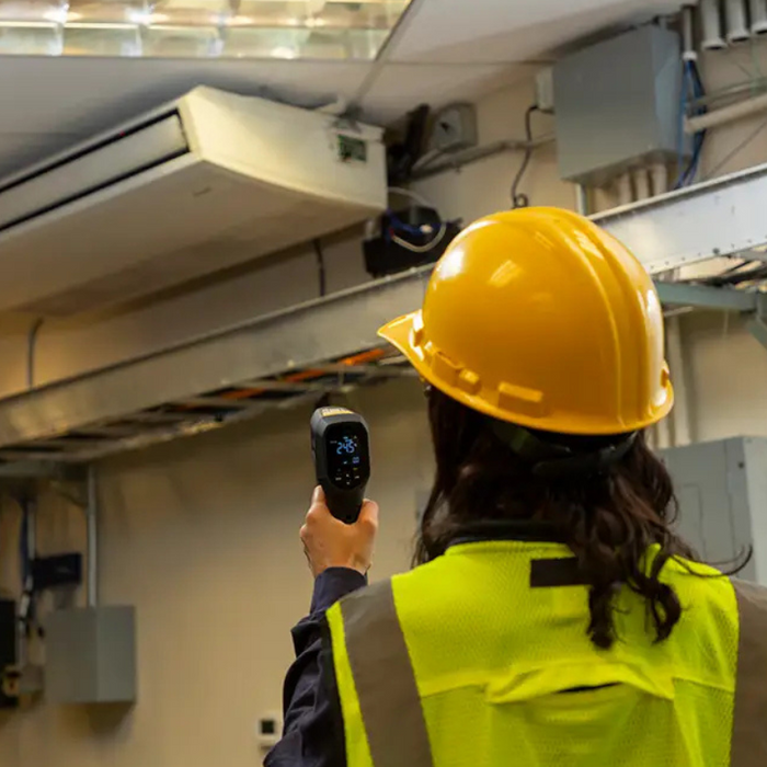Teledyne Flir Sv89 Remote Vibration Temperature Sensor worker using sensor on ceiling vent yellow hard hat.