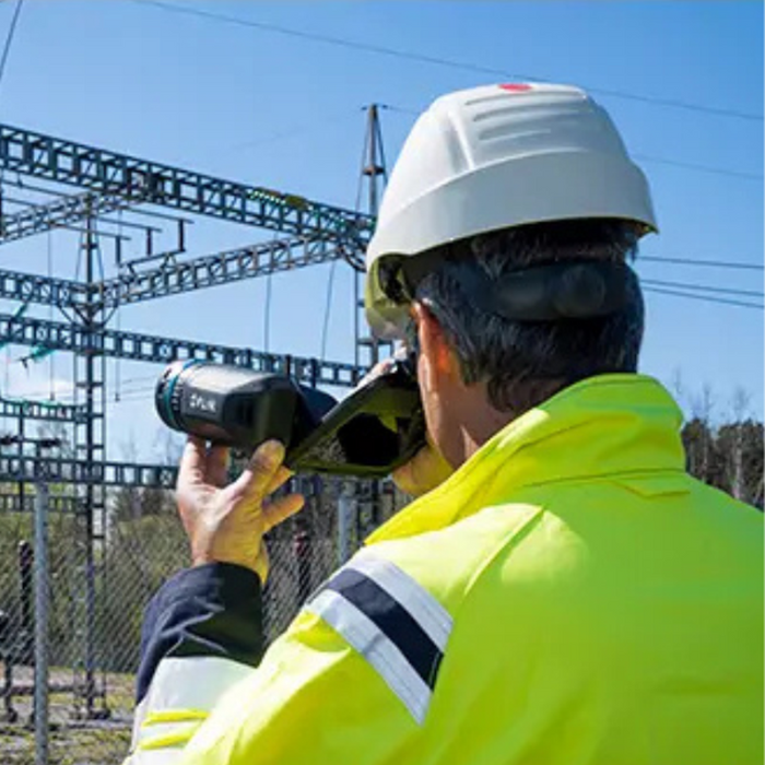 Teledyne Flir T530 Dfov 14 24 technician using camera to scan substation from behind.