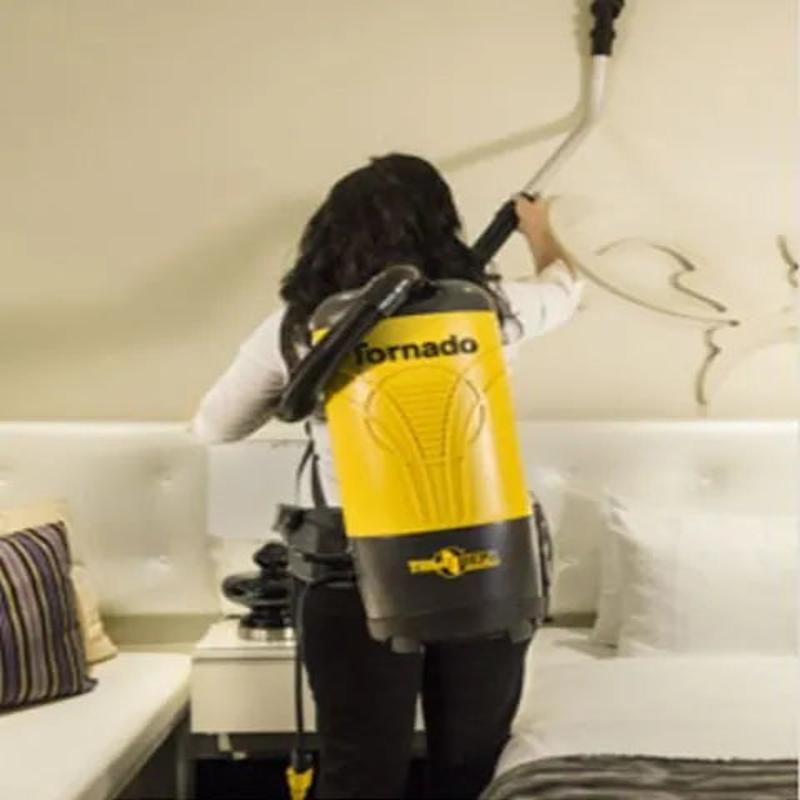 Tornado Pac Vac 6 Aircomfort back view woman using vacuum on wall.