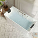Modern white bathtub filled with blue water, geometric tile floor, potted plant on wooden stool nearby