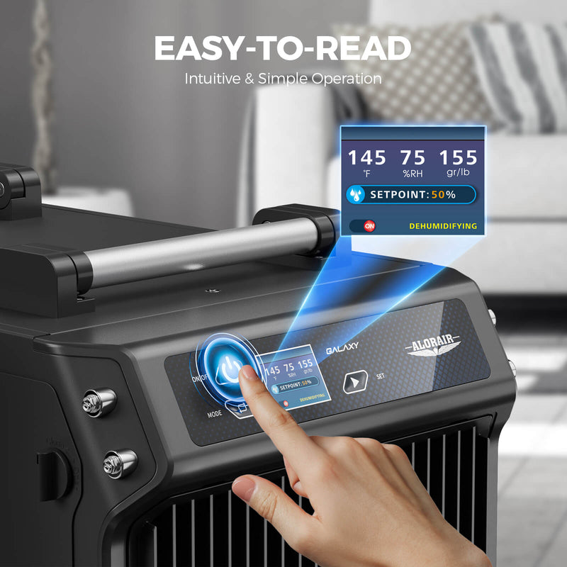Finger pressing the power button on the AlorAir Galaxy 60 display showing temperature, humidity, grains per pound and a 50% setpoint