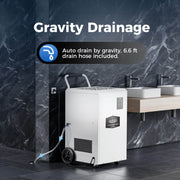 AlorAir Sentinel SLGR 1400X in a bathroom draining through its hose to the floor, captioned Gravity Drainage with a 6.6' drain hose included