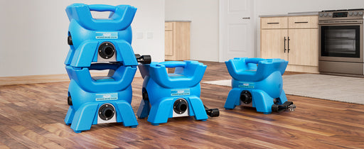 Several blue AlorAir X-Force blowers stacked two high and standing on a kitchen floor