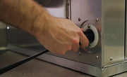 AnteRoom exterior power inlet with a power cord being plugged in at the base of the unit