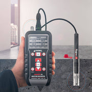 Tramex Concrete Determinator Inspector Kit - CDIK: image shows the Tramex CMEX5 Hygro-i2 probe with a digital display, showcasing its use for measuring moisture in concrete and other materials, accompanied by a background depicting a construction site.