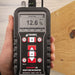 Tramex Flooring Inspector EZ Kit - FZK: An image showing the Tramex CMEX5 moisture meter with a pin probe, placed on wooden flooring for moisture inspection. The device features a digital display and is designed for assessing moisture content in various flooring materials.