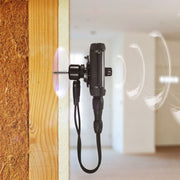 Tramex AP-TREMS-WME-MC - Remote Environmental Monitoring System WME/MC Accessory Pack. The image shows the Tramex Remote Environmental Monitoring System mounted on drywall in a residential hall, featuring a sleek design and a wireless contact sensor for humidity and temperature monitoring.