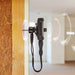 Tramex AP-TREMS-WME-MC - Remote Environmental Monitoring System WME/MC Accessory Pack. The image shows the Tramex Remote Environmental Monitoring System mounted on drywall in a residential hall, featuring a sleek design and a wireless contact sensor for humidity and temperature monitoring.