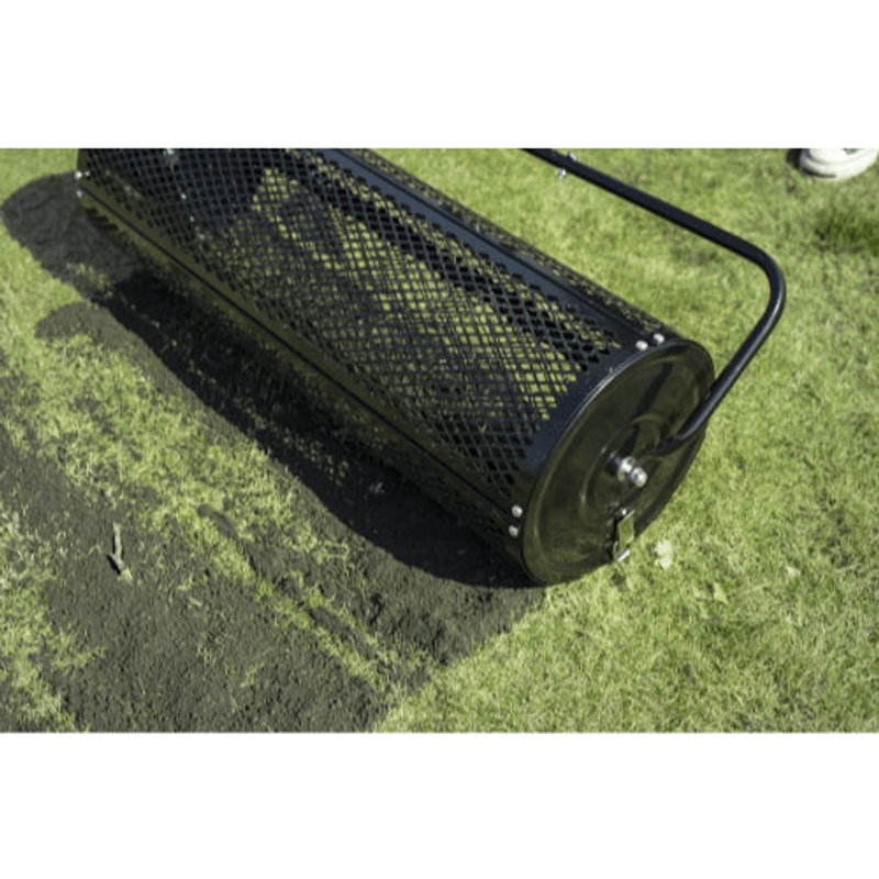 Dapper Supply 36-inch compost spreader steel mesh drum spreading on grass.