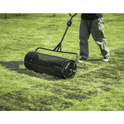 Dapper Supply 36-inch compost spreader being pushed across a green lawn.