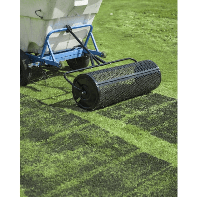Dapper Supply 44-inch compost spreader towed behind a lawn unit on turf.