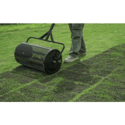 Dapper Supply compost spreader drum close-up while spreading compost on a lawn.