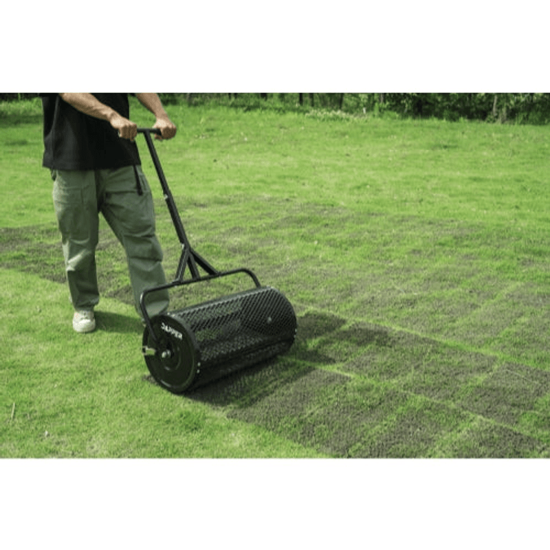 Dapper Supply compost spreader being pushed across a lawn to top-dress the grass.