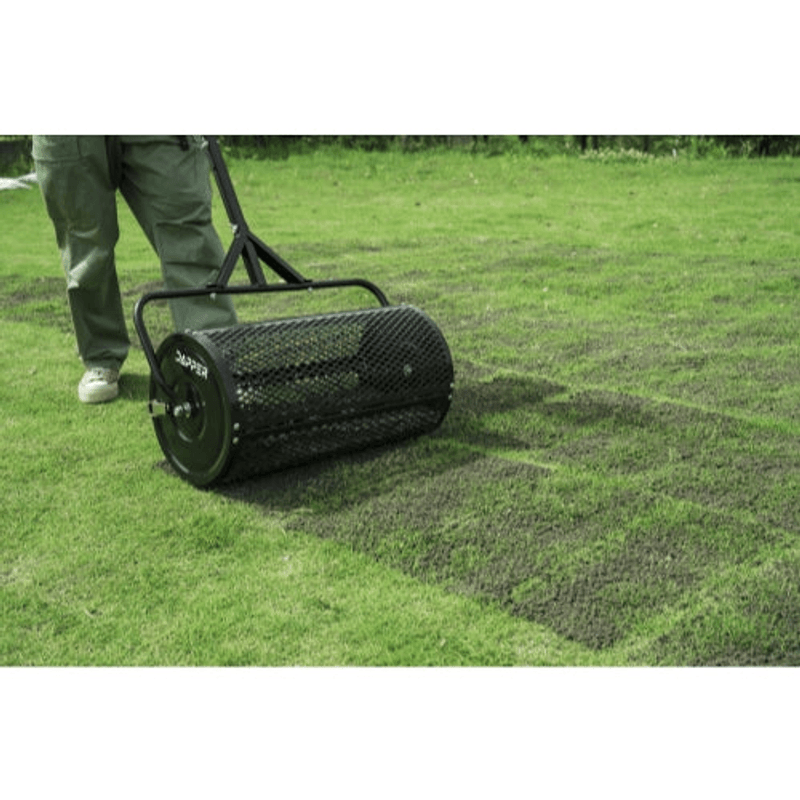 Dapper Supply compost spreader rolling over freshly top-dressed turf in a yard.