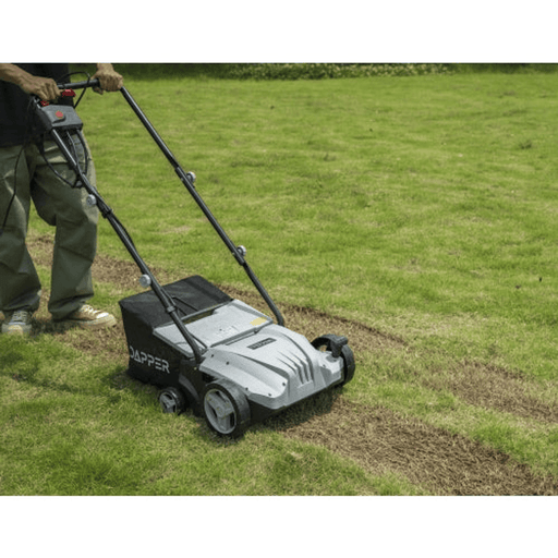 Dapper Supply 13-inch electric dethatcher and scarifier raking thatch from a lawn.