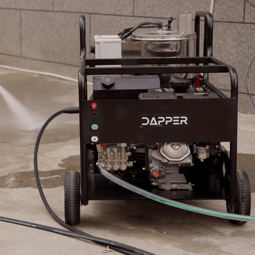 Dapper Supply hot water gas pressure washer in use spraying on a concrete surface.