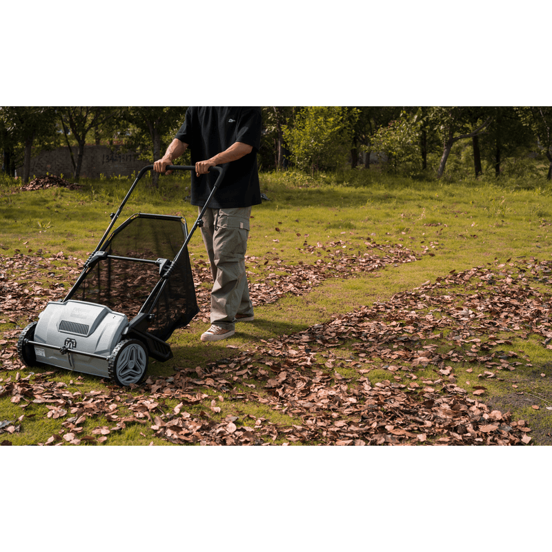 Dapper Supply lawn sweeper being pushed across a leaf-covered lawn.