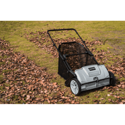 Dapper Supply lawn sweeper clearing leaves on a grassy lawn.