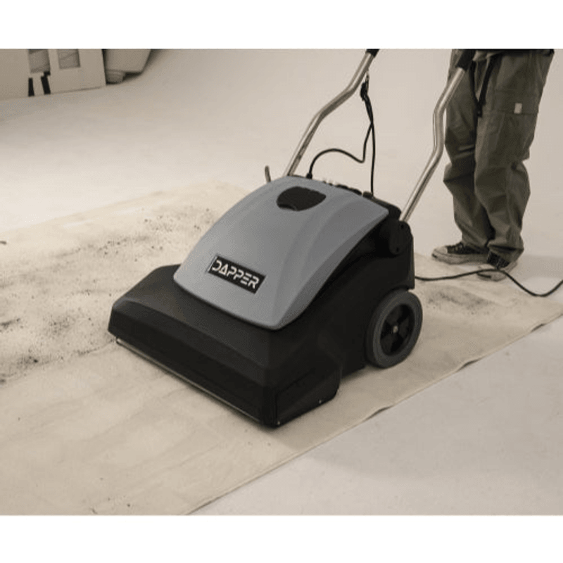 Dapper Supply 26-inch wide area vacuum in use removing debris from a large carpeted floor.