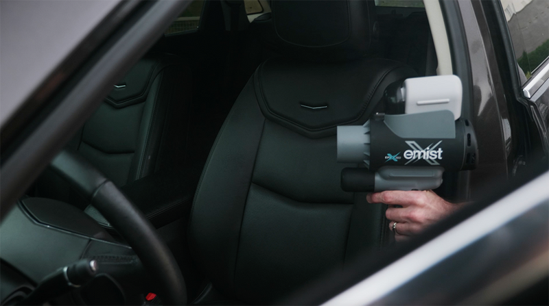 EMist EPIX360 handheld sprayer aimed at a vehicle driver seat