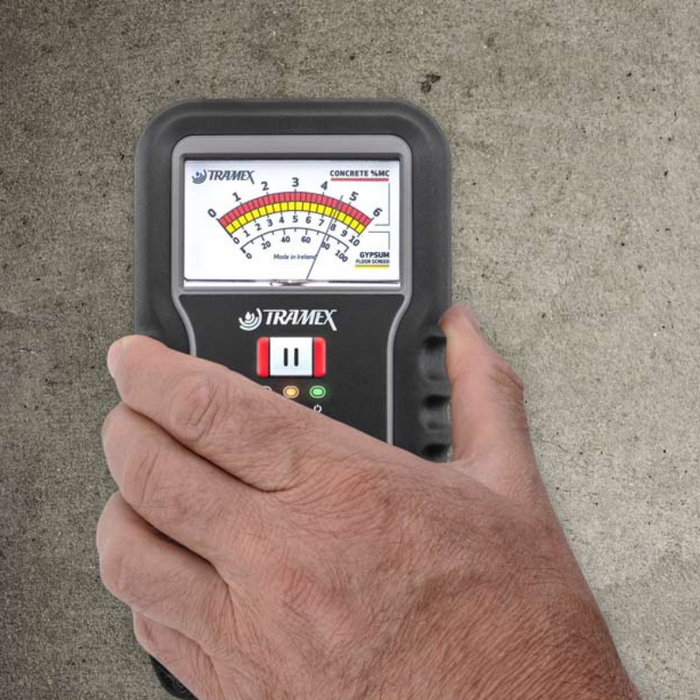 Tramex Flooring Installation Quick Check Kit - IQCK An image showing the Tramex IQCK being used to check moisture levels in concrete, featuring a user applying the device with visuals of the meter reading in focus.