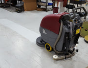 Minuteman E20 Sport on a shop floor beside a strip of floor finish it has removed