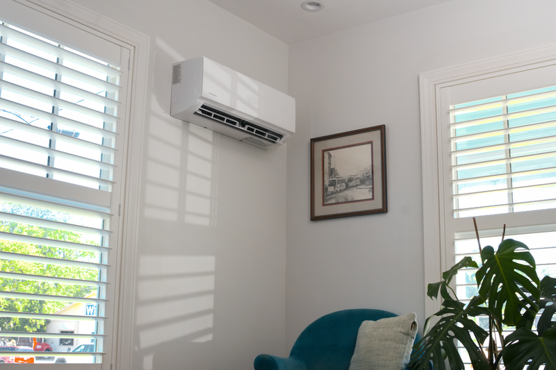 White DIY Select air handler mounted high in the corner of a room with shuttered windows