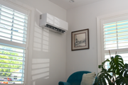 White DIY Select air handler mounted high in the corner of a room with shuttered windows