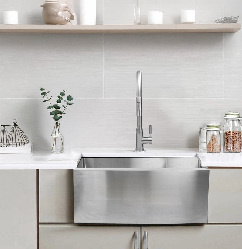 Nantucket Sinks APRON2420-SR-16 installed in a light kitchen beneath open shelving