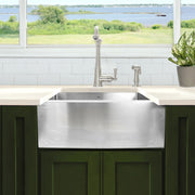 Nantucket Sinks APRON2420-SR-16 stainless apron front under a window over dark green cabinets