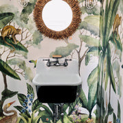 Nantucket Sinks CI-2218WNRG utility sink wall-mounted against tropical wallpaper under a round mirror