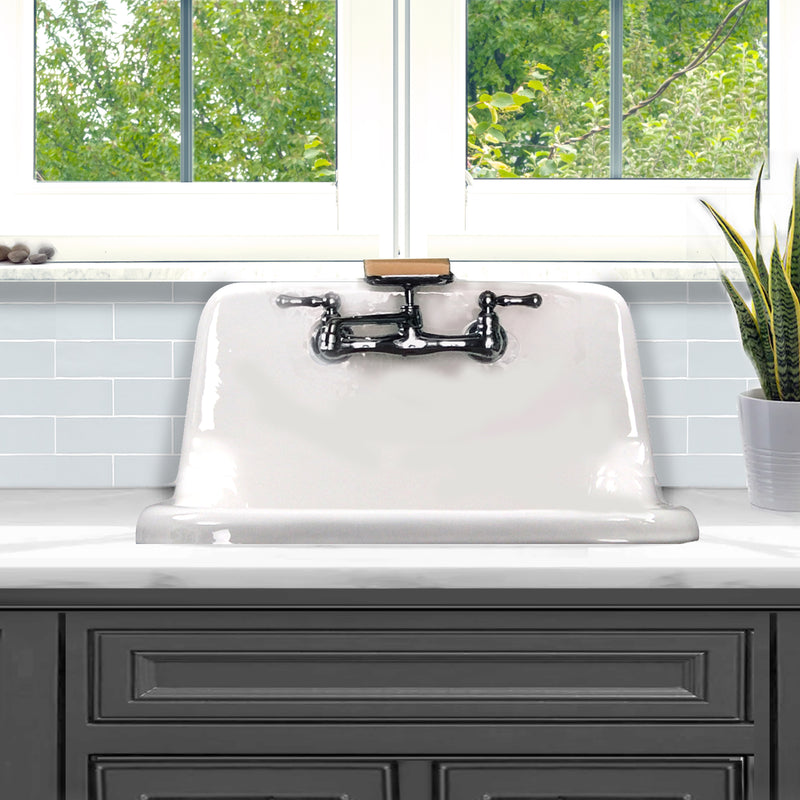 Nantucket Sinks CI-2218WNRG white cast iron utility sink with a chrome faucet set above a dark gray cabinet