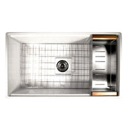 Nantucket Sinks DC-TFCPS colander resting on the ledge of a stainless workstation sink beside the bottom grid