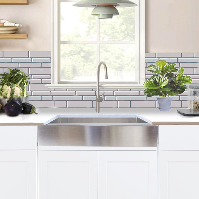 Nantucket Sinks EZApron33-5.5 installed under a window in a white kitchen with subway tile