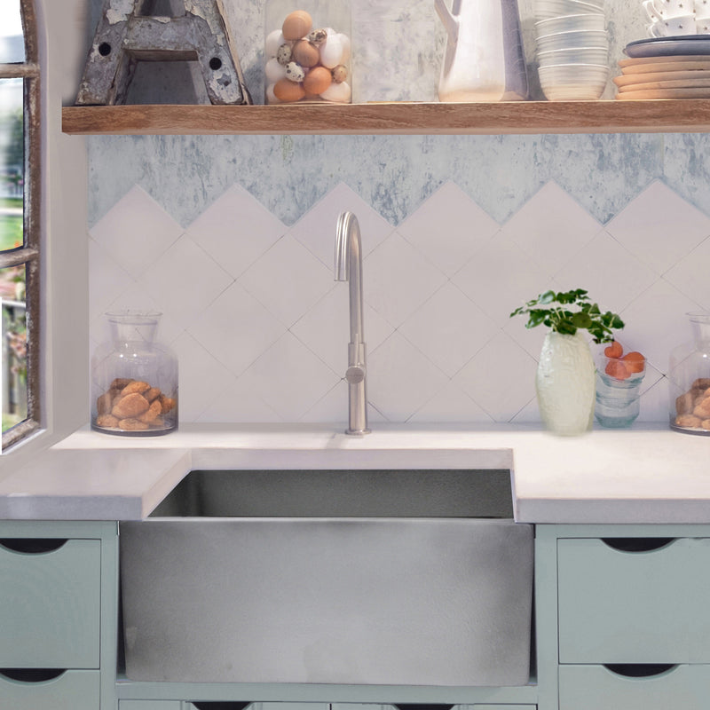 Nantucket Sinks FCFS2418S-Concrete Concrete farmhouse sink under a white counter with blue-green cabinets and open shelf