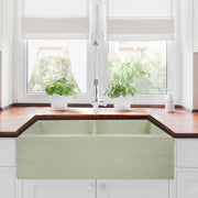 Nantucket Sinks FCFS3318D-ShabbyGreen Shabby Green double bowl farmhouse sink below a window with a wood counter