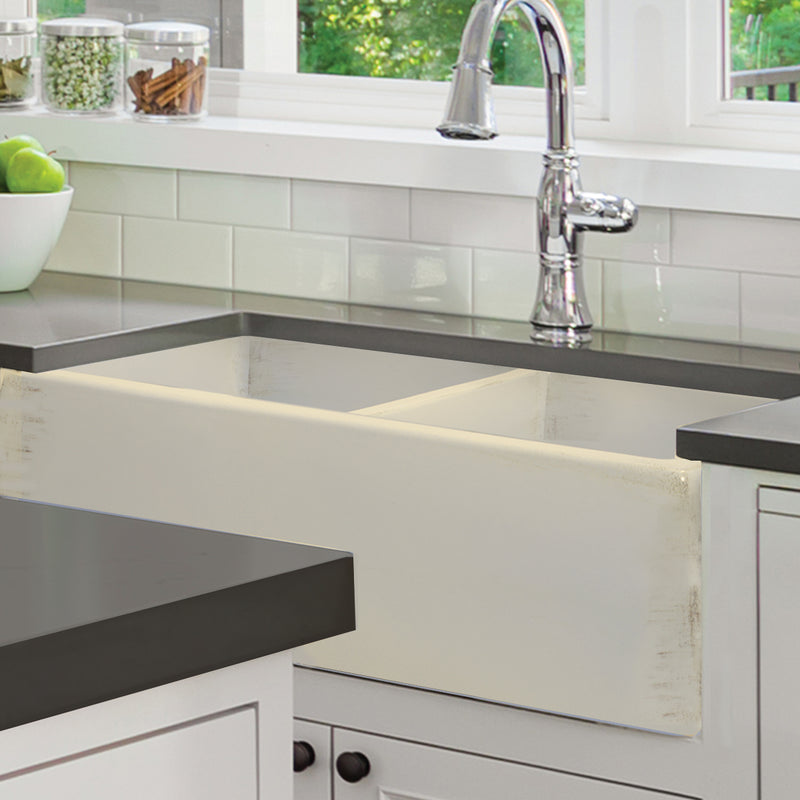 Nantucket Sinks FCFS3318D-ShabbyStraw Shabby Straw double bowl farmhouse sink under a dark counter in a white kitchen