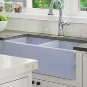 Nantucket Sinks FCFS3318D-ShabbySugar Shabby Sugar double bowl farmhouse sink under a dark counter in a white kitchen