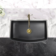 Nantucket Sinks FCFS3320CA-MB Matte Black curved apron sink from above in a marble counter with brass drain