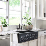 Nantucket Sinks FCFS3320S-FiligreeMBL Matte Black Filigree farmhouse sink in a white kitchen with a bridge faucet