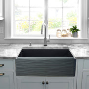 Nantucket Sinks FCFS3320S-MB-Waves Matte Black Waves farmhouse sink below a window with grey stone counters