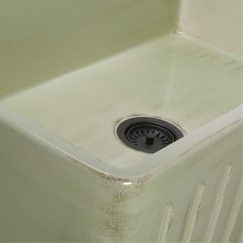 Nantucket Sinks FCFS3320S-ShabbyGreen close-up of the distressed Shabby Green glaze and fluted apron edge by the drain