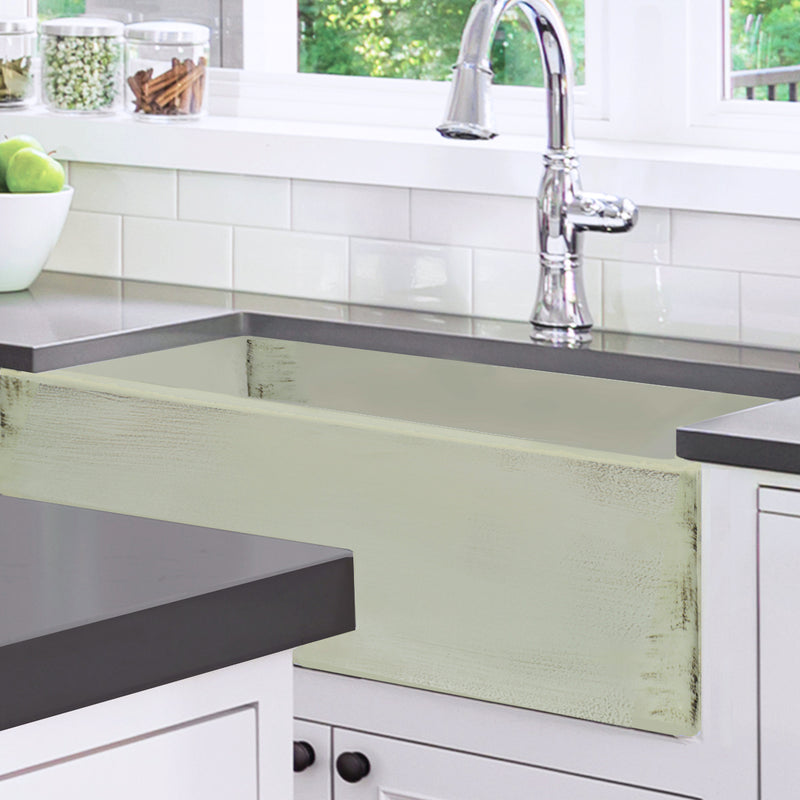 Nantucket Sinks FCFS3320S-ShabbyGreen Shabby Green farmhouse sink under a dark counter in a white kitchen