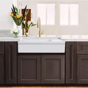 Nantucket Sinks FCFS36-DB drainboard farmhouse sink in dark wood cabinets with a brass faucet