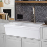 Nantucket Sinks FCFS36-DB drainboard farmhouse sink below a herringbone tile wall and open wood shelf