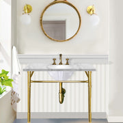 Nantucket Sinks GB-13x10-W oval undermount sink under a marble top on a brass console vanity