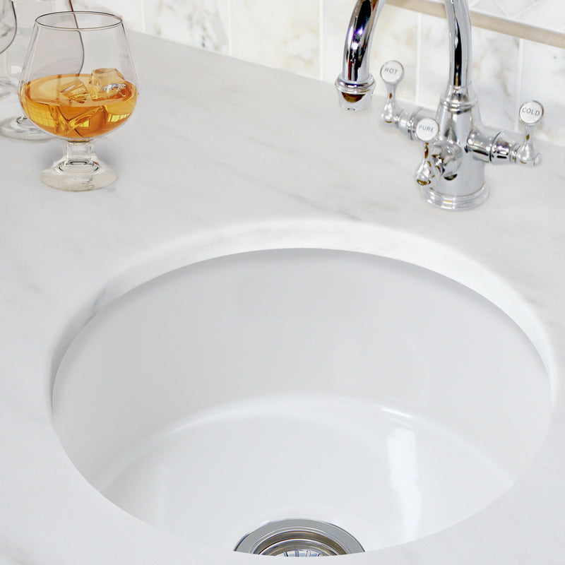 Nantucket Sinks Hyannis-18 round bar sink undermounted in white marble beside a chrome bar faucet