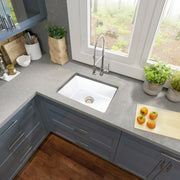 Nantucket Sinks ISFC24W-SB1 white single bowl sink in a grey corner counter with blue cabinets